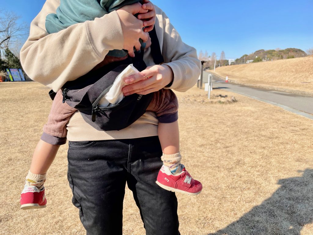 息子をボーンブーンで抱っこしたままティッシュを取り出そうとする写真。
