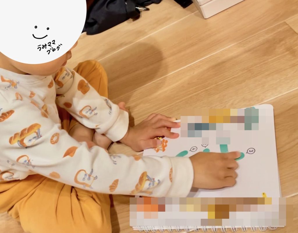息子がモンテッソーリ式すなもじ本をひとりで開き、文字をなぞっている様子